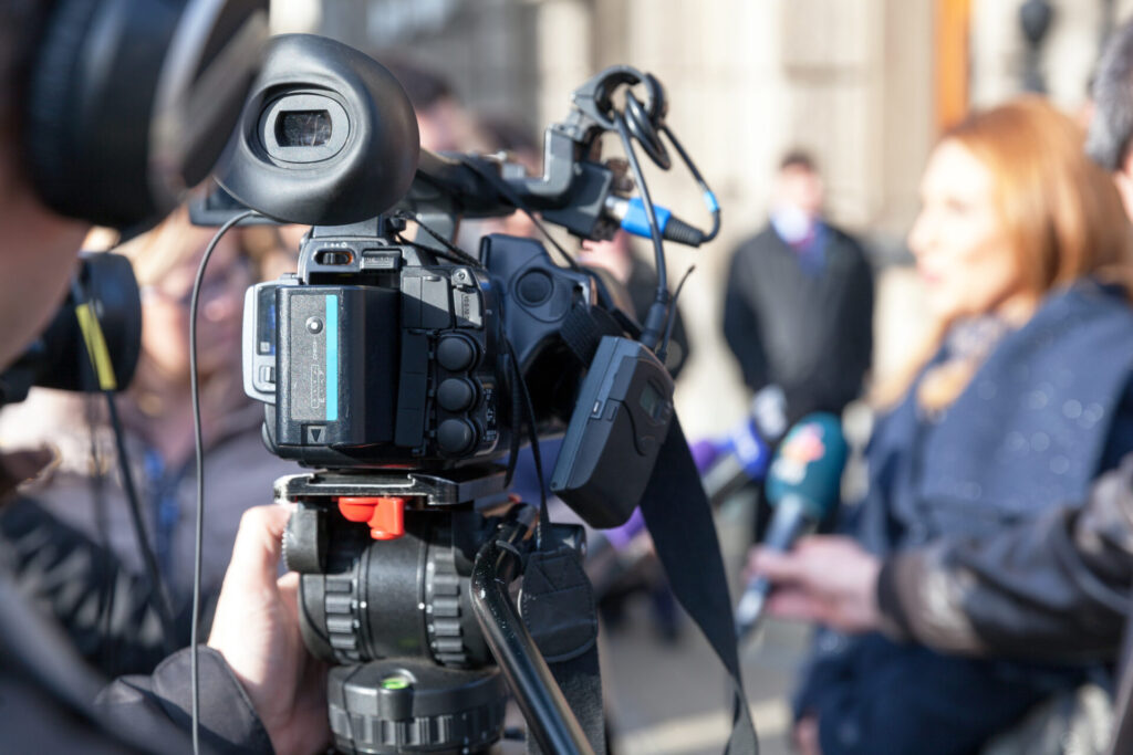 Camera filming newsperson