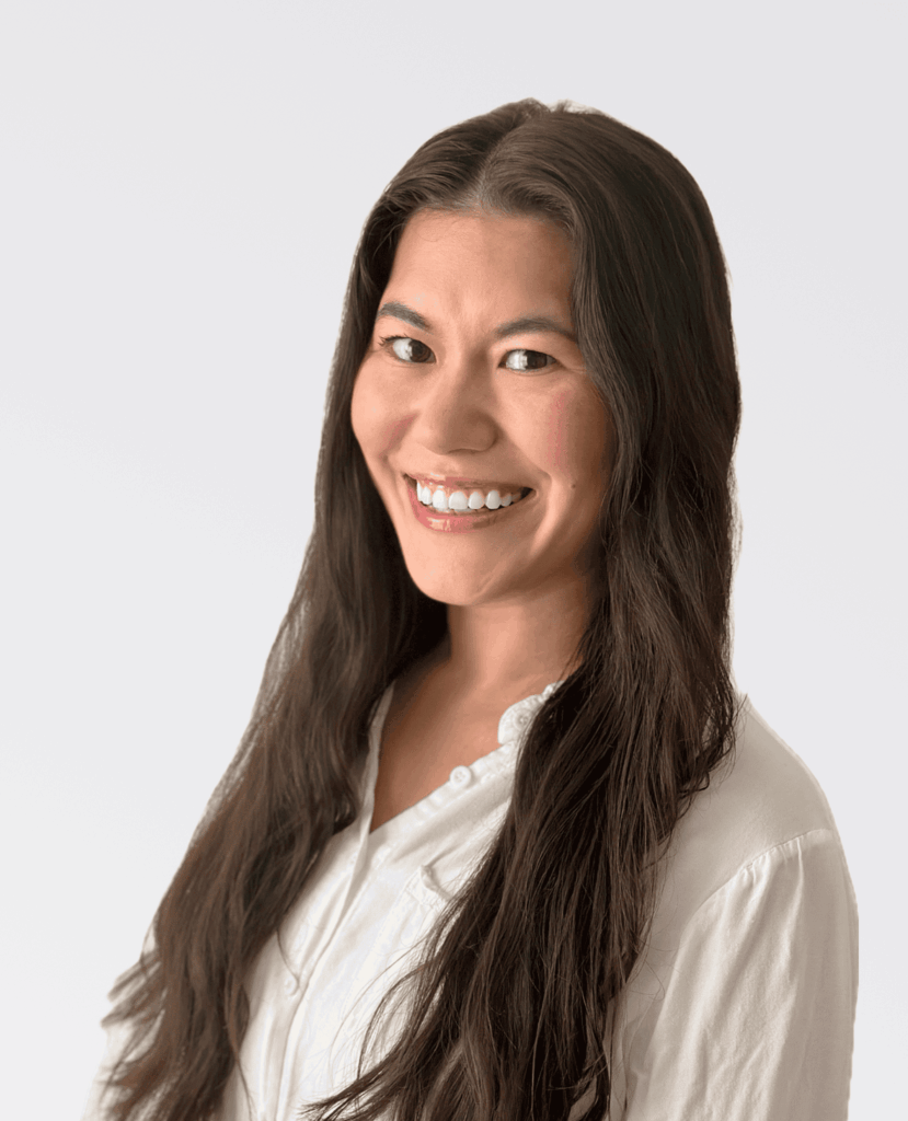 Professional headshot of a smiling woman in a white shirt